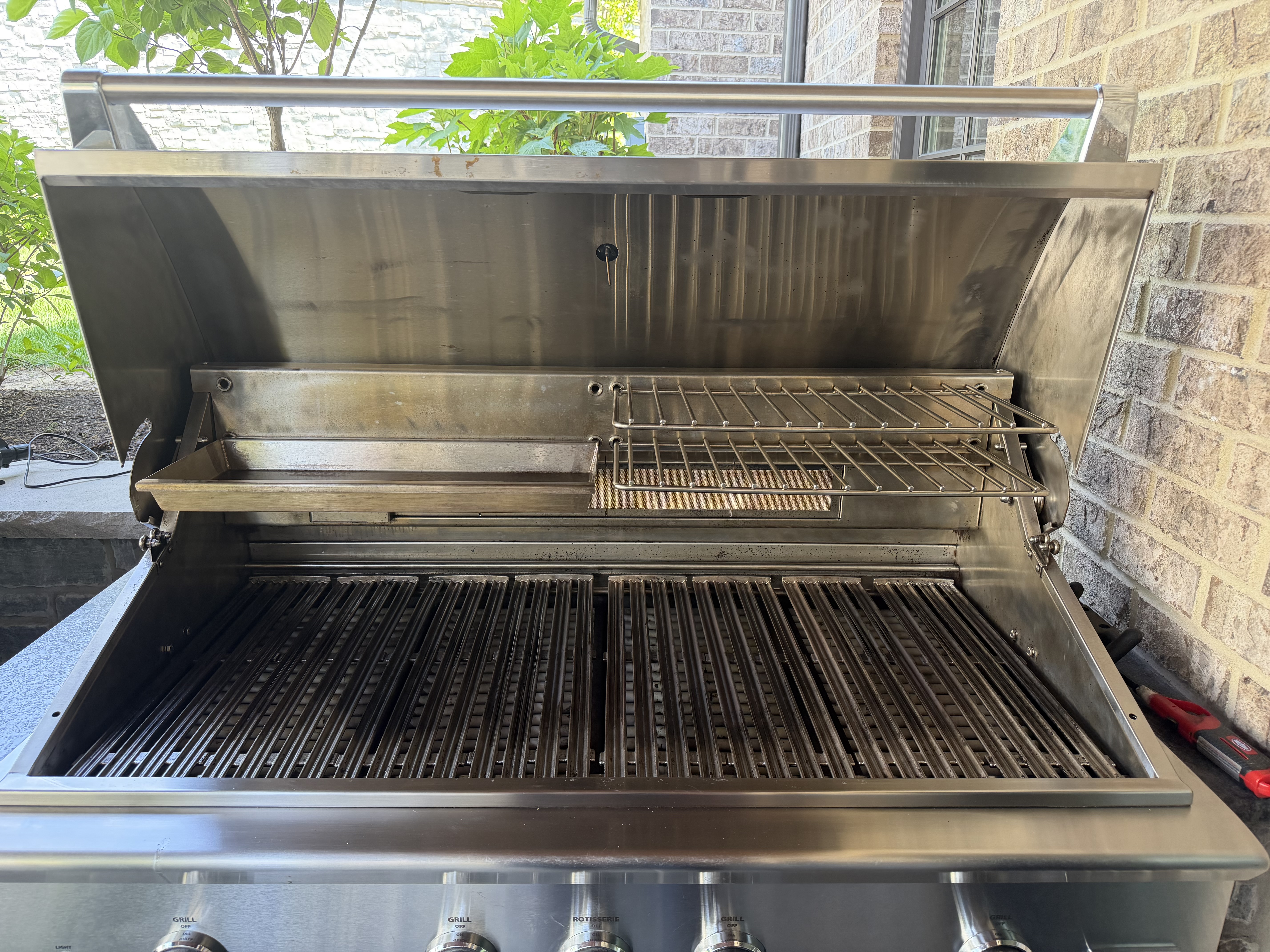 After: the same DCS 5-burner built-in with a clean stainless hood, polished cookbox, and restored grates